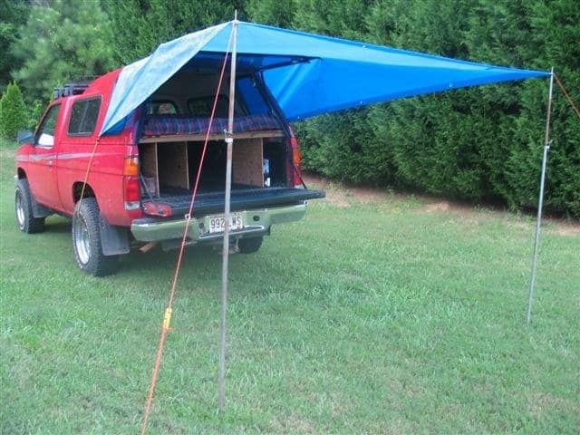 8. Then boost up the tarp with two poles or sticks to make a covered porch for sitting, eating, and shade.