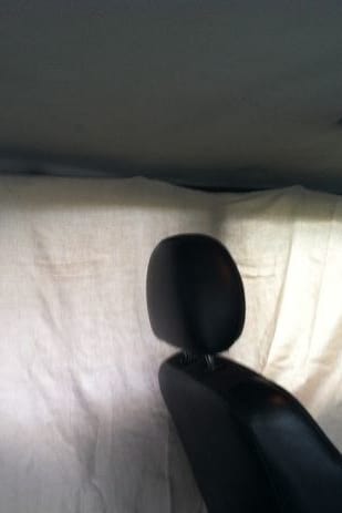 4. Turn a sheet into a privacy curtain by slipping binder clips into the gap between your car's plastic and upholstery.