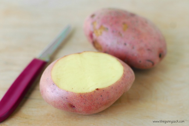 Begin by slicing off the top of the raw potato. 